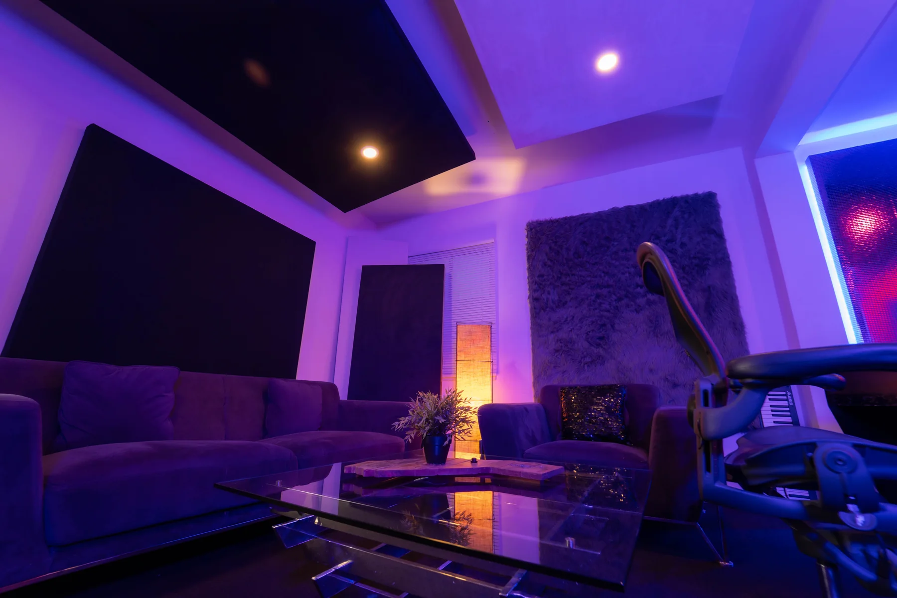 Studio A lounge seating and acoustic treatment under purple lighting